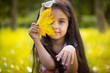 © spass - Cute hispanic girl  hiding over yellow leaf