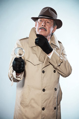 Retro detective man with mustache and hat. Holding magnifying gl