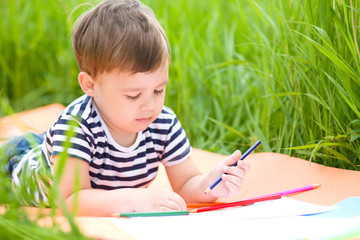 Wall Mural - Little boy is playing with pencils