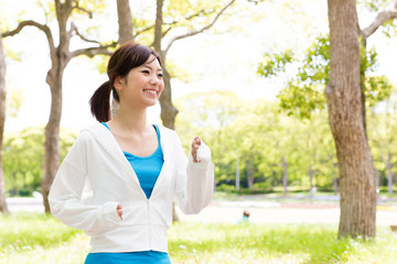 Wall Mural - young asian woman jogging in the park