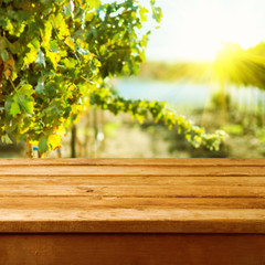 Wall Mural - Empty wooden deck table over vineyard bokeh background