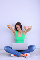 Canvas Print - Beautiful young woman sitting with laptop in room