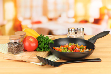 Wall Mural - Vegetable ragout in pan,  on wooden table on bright background