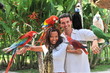 Young couple with tropical birds on bali island Indonesia
