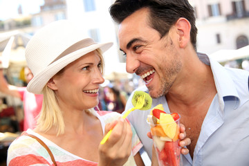 Couple of tourists having fun eating fresh fruits