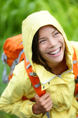 Wall Mural - Happy hiker woman hiking in rain with backpack