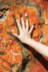 hand and painting on rock