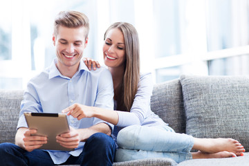 Wall Mural - Couple on sofa with digital tablet