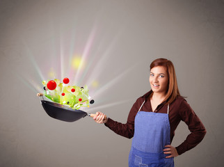 Wall Mural - Young woman cooking fresh vegetables