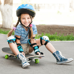 little girl sitting on a skateboard