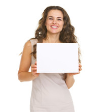 Portrait Of Happy Young Woman Showing Blank Paper
