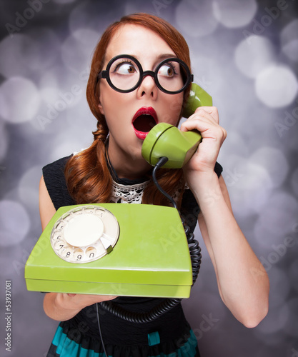 Naklejka dekoracyjna Redhead women with green telephone.