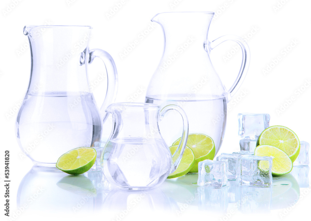 Glass pitchers of water with ice and lime isolated on white