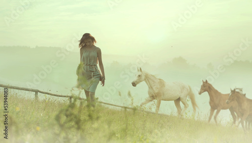 Naklejka ścienna Pretty brunette lady resting among horses