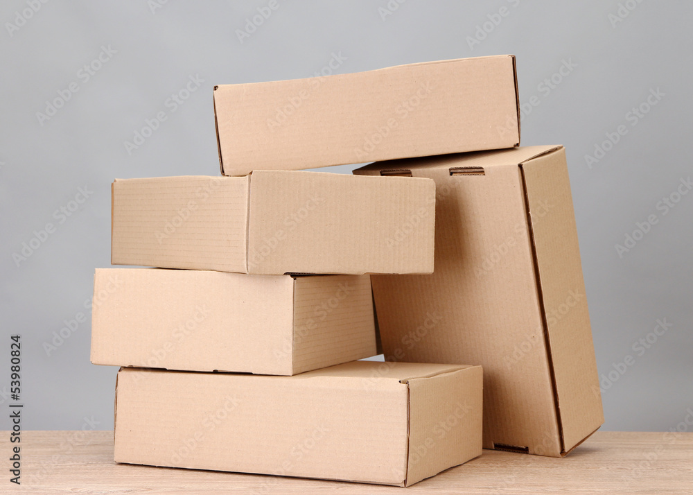 Parcels boxes on wooden table, on grey background