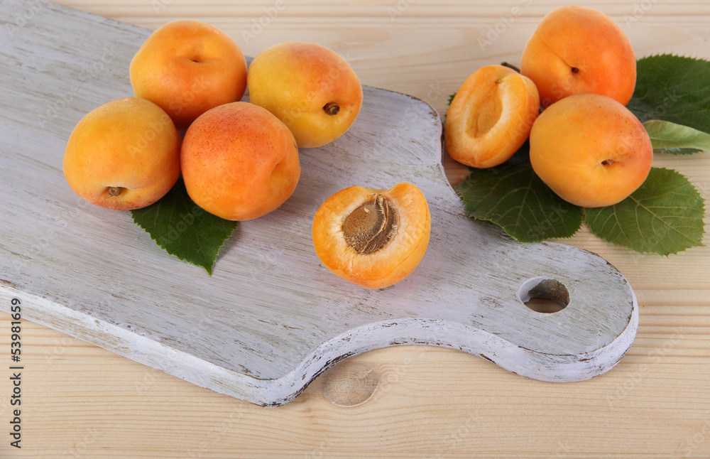 Apricots on board on wooden table