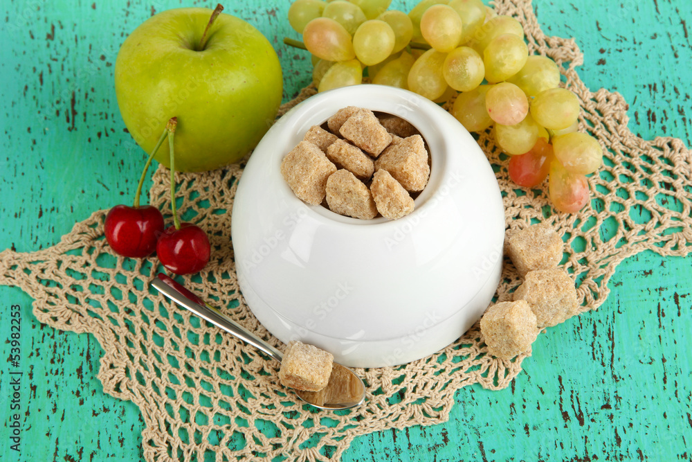 Unrefined sugar in white sugar bowl on wooden background