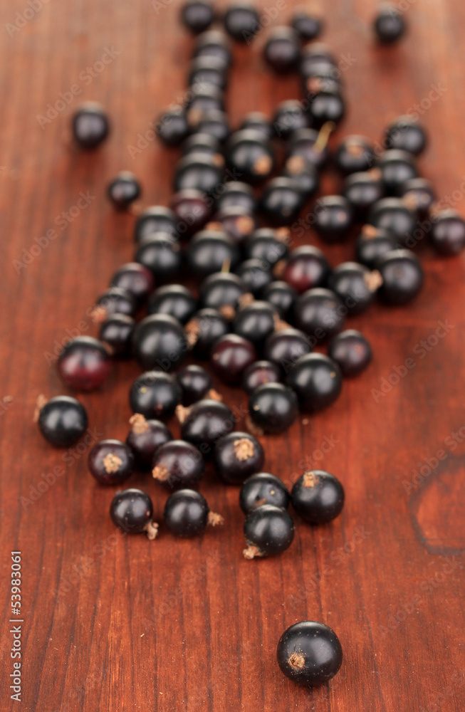 Fresh black currant on wooden background