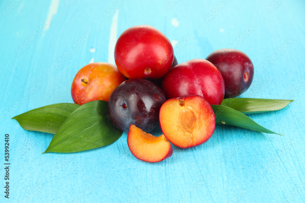 Ripe plums on wooden table close-up