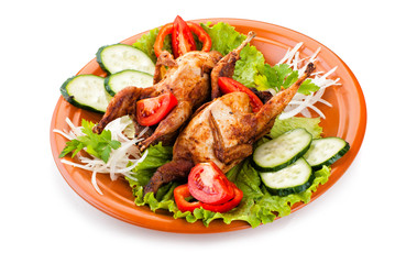 Two whole quail with cucumber, tomatoes and onion