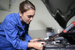 © goodluz - Student girl in mechanics working on car engine