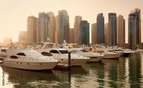 Fototapeta na wymiar Skyscrapers and Yachts in Dubai Marina During Sunset