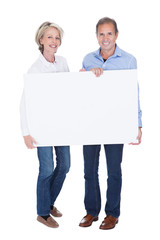 Portrait Of Mature Couple Holding Placard