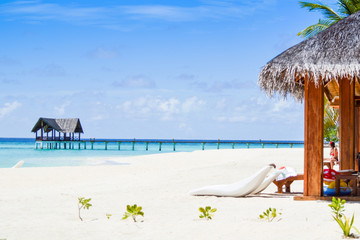 Wall Mural - Beach chairs and grass umbrellas at resort