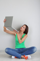 Wall Mural - Beautiful young woman sitting with laptop in room