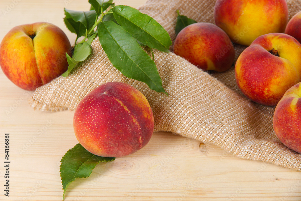 Peaches on sackcloth on wooden table