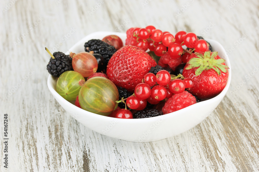 Ripe berries in bowl on table close-up
