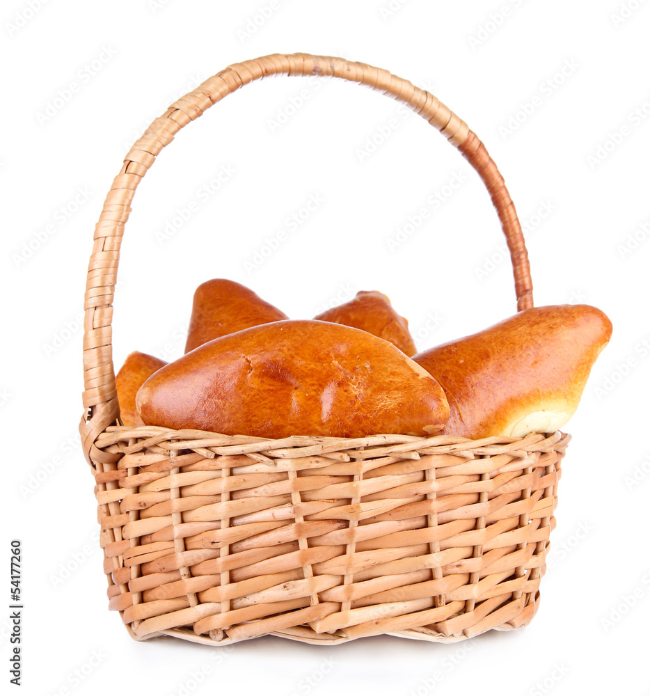 Fresh baked pasties in wicker basket, isolated on white