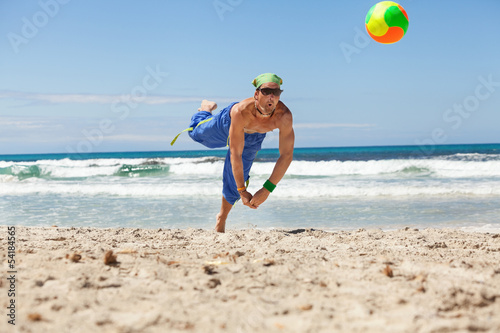 Naklejka samoprzylepna Dorosły młody człowiek sportowy gra w siatkówkę plażową