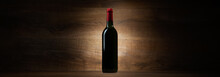 Green Bottle With Red Wine On A Wood Panorama Background