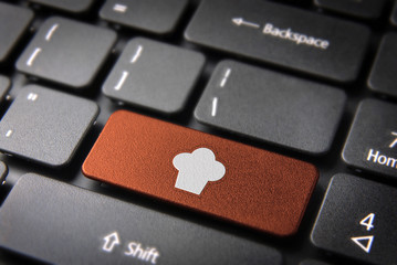 Wall Mural - orange chef hat keyboard key, food background