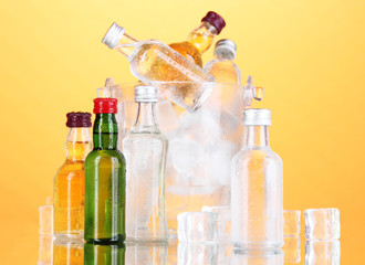 Poster - Minibar bottles in bucket with ice cubes,  on color background