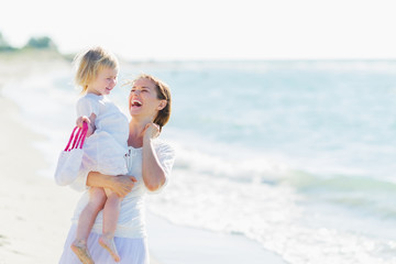 Wall Mural - Portrait of smiling mother and baby on beach