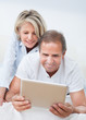 © Andrey Popov - Happy Mature Couple Looking At Digital Tablet