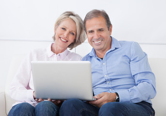 Wall Mural - Happy Mature Couple Working On Laptop