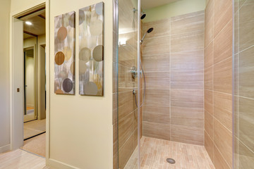 Wall Mural - Bathroom shower with glass doors and natural color tiles.