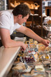 © Milles Studio - Shopkeeper working in a cheese glass case in a grocery store