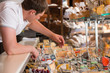 © Milles Studio - Shopkeeper working in a cheese glass case in a grocery store