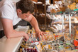 © Milles Studio - Shopkeeper working in a cheese glass case in a grocery store