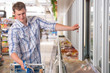 © Milles Studio - Man in a supermarket standing in front of the freezer