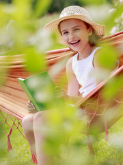 Wall Mural - Summer joy - girl with book resting on a hammock in t