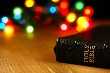 Wall Mural - Holiday background with blurred lights and Bible