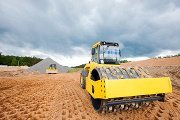 Road roller and bulldozer during highway construction works