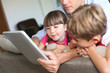 © goodluz - Father and children playing with tablet at home