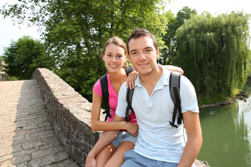 Wall Mural - Couple on a rambling day sitting on a roman bridge