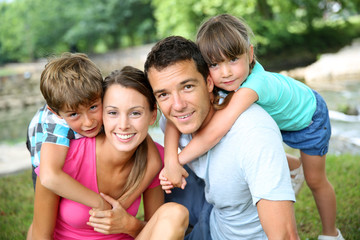 Family relaxing by river in countryside